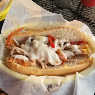 a chicken sandwich with cheese and peppers