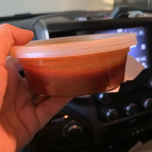 a person holding a bowl of sauce