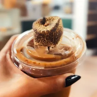 a person holding a cup of coffee and a donut