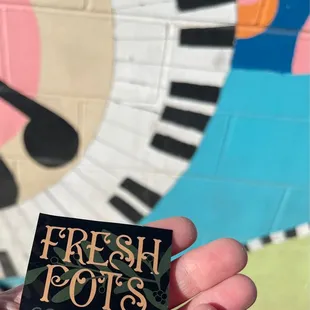 a hand holding a coffee bar sign