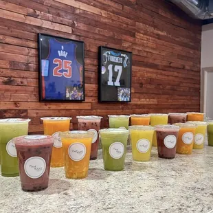 a variety of cold drinks lined up on a counter