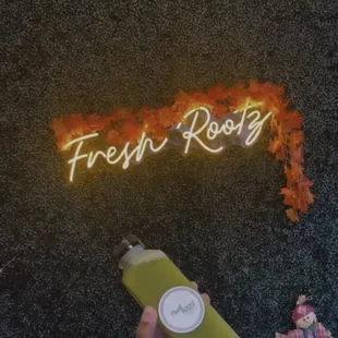 a hand holding a bottle of fresh rootz