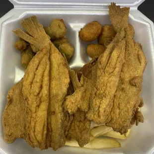 fried fish and potatoes in a styrofoam container