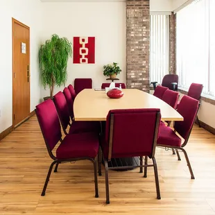 a long table with red chairs