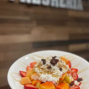 a plate of fruit and whipped cream