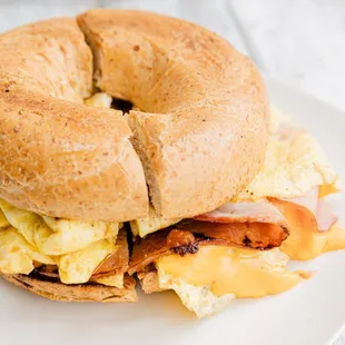 a bagel sandwich with eggs and bacon