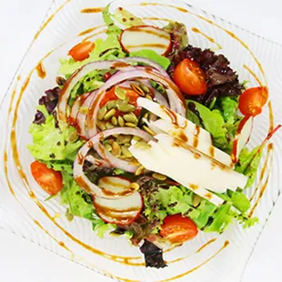 Green Garden Salad.Fresh green leafs blend, juicy grape tomato, thinly sliced red onions, sliced fresh jicama and dressing.