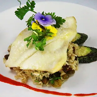 Cajun Spiced Sea Bass Flaky chilean seabass served over a bed of cilantro spiced brown rice with turkey bacon bits.