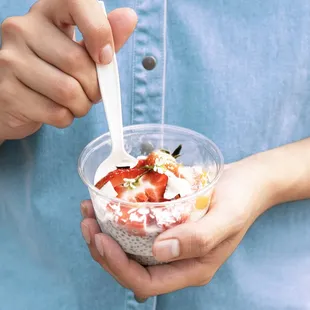 a person holding a bowl of yogurt