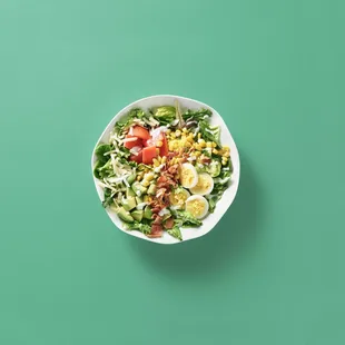 a bowl of salad on a green background