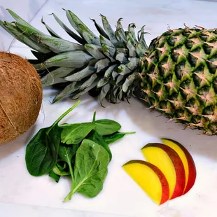 a pineapple, spinach, mango, and coconut