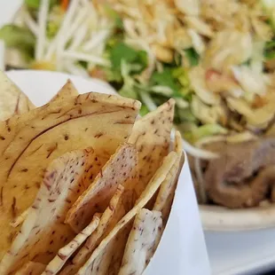 Salad bowl with pork. Side of taro chips.