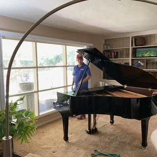 Baby grand makes it's home  in my living room... Guys setting it up...