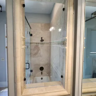 Stunning frameless stationary window really completes the bathroom remodel.