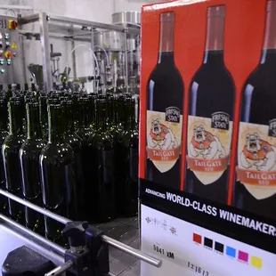 a line of bottles being filled with wine