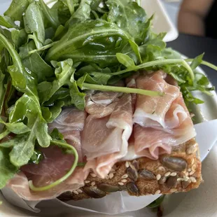 Prosciutto, Brie on pumpkin seed bread topped with arugula