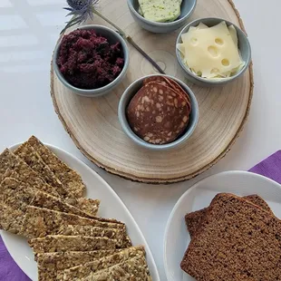 a plate of crackers, bread, and other snacks