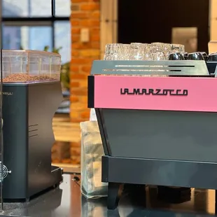 a pink and black coffee machine