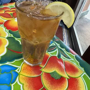 a glass of iced tea with a lemon wedge