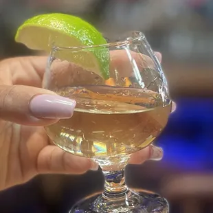 a person holding a glass of alcohol