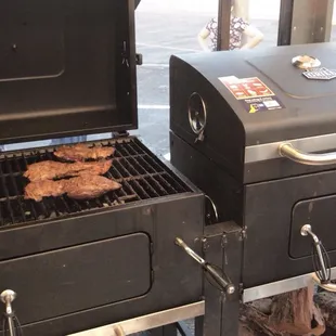 two grills with meat on them