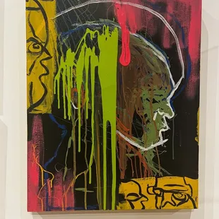 a painting of a man's face with green, red, yellow, and black