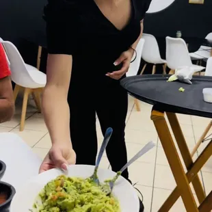 a woman serving a bowl of guacamole