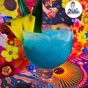 a blue drink with a pineapple garnish