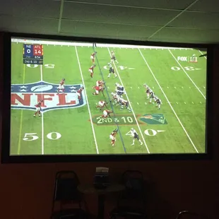 Three large TVs and big screen projector for watching sports.