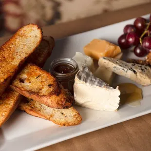 a platter of cheese, crackers, and fruit