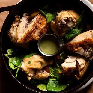 a skillet with chicken and spinach