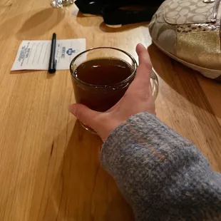 a person holding a glass of cider