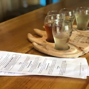 three glasses of cid on a wooden tray