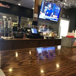 a bar with a television and wine glasses
