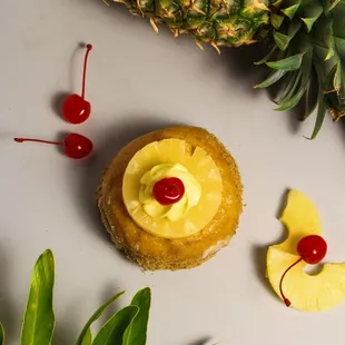 May - Pineapple Upside Down : Dipped in white chocolate, w/ a Nilla wafer crumble bottom. A creamy custard filling. Pineapple and cherry.
