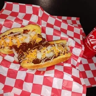 two chili dogs with cheese and onions