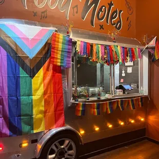 a food cart decorated with a rainbow flag