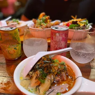 a bowl of ramen and a can of soda