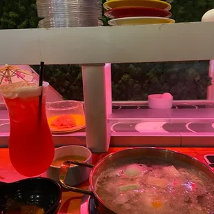 a bowl of soup and a drink on a table
