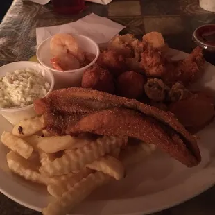a plate of fried fish, fries, and coleslaw