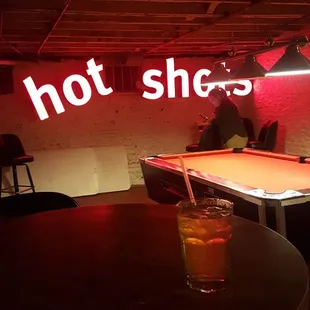a pool table and neon sign