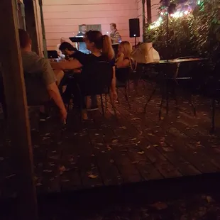 a group of people sitting at a table outside at night