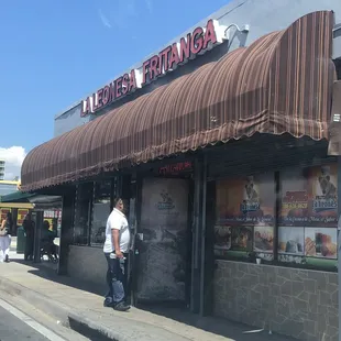 a man standing outside a restaurant