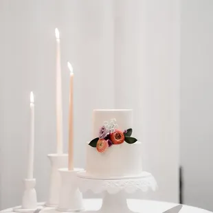 a white wedding cake with flowers and candles