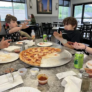 a family eating pizza at a restaurant