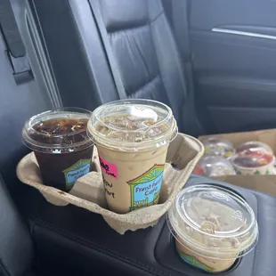 two cups of iced coffee and a box of donuts