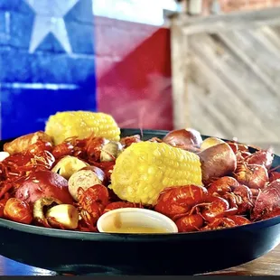 a bowl of craw and corn on the cob