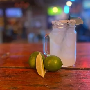 a glass of lemonade and limes