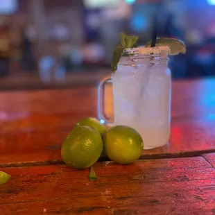 limes and a mason jar on a wooden table