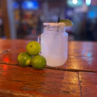 a jar of lemonade and limes